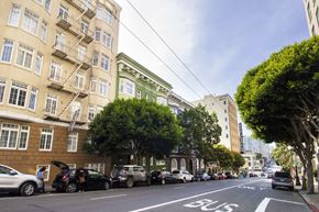 San Francisco apartment for rent - A street with a bus lane and cars parked on the side.