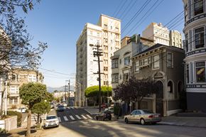 San Francisco apartment for rent - A street view of a residential area with cars parked on the side of the road.