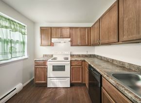 Cohoes apartment for rent - a kitchen with wooden cabinets and white appliances and a window