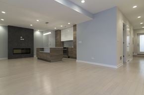 Chicago apartment for rent - an empty living room with a fireplace and a kitchen