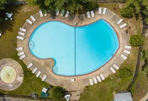 Lindenwold apartment for rent - An aerial view of a heart-shaped swimming pool surrounded by lounge chairs.
