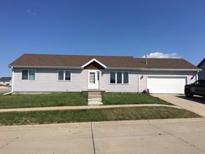 Winnebago apartment for rent - a white house with a brown roof on a lawn