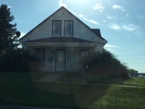 Emerson apartment for rent - the front of a white house with a lawn and a blue sky