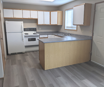 Brandon apartment for rent - A kitchen with a white refrigerator, white oven, and white cabinets.