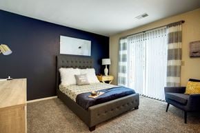 Portage apartment for rent - a bedroom with a bed and a blue accent wall