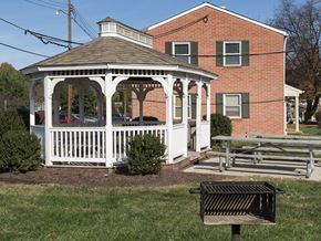 Frederick apartment for rent - a gazebo with a picnic table in front of a house