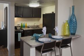 Davie apartment for rent - a view of a kitchen with a dining table and black appliances
