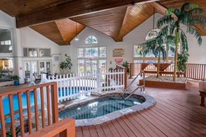 Omaha apartment for rent - a hot tub is in the middle of a house with a porch