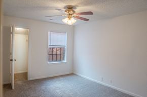 Omaha apartment for rent - A room with a ceiling fan and a window with a view of a building outside.