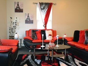 Fall River apartment for rent - a living room with red furniture and a black and white rug