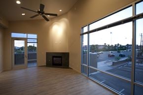 Tucson apartment for rent - an empty living room with a fireplace and a large window