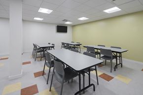 Chicago apartment for rent - a classroom room with tables and chairs and a tv