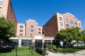 Chicago apartment for rent - a large brick building with a fence in front of it