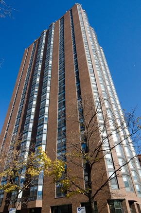 Chicago apartment for rent - a tall building with many windows against a blue sky