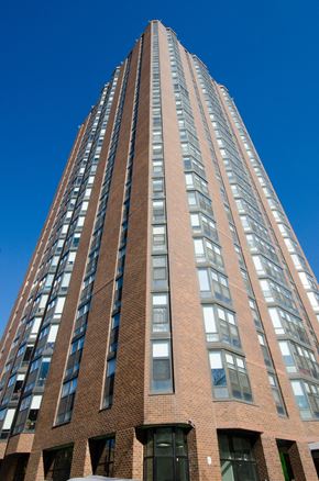 Chicago apartment for rent - a tall brick building against a blue sky