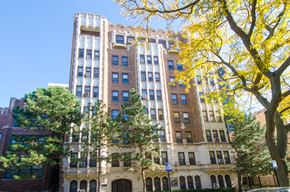 Chicago apartment for rent - a tall brick building with trees in front of it
