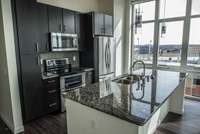 Green Bay apartment for rent - A kitchen with black cabinets and granite countertops.