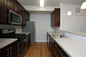 Hillsborough apartment for rent - Kitchen with hardwood floors, stainless steel appliances, and dark wooden cabinets