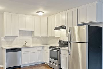 Oak Park apartment for rent - A kitchen with white cabinets and a black refrigerator.