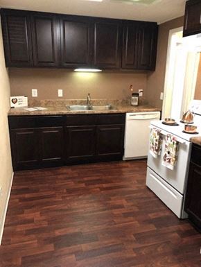 Lake Mary apartment for rent - a kitchen with wooden floors and black cabinets