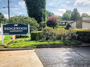 Decatur apartment for rent - a sign for ridgewood apartments in front of a yard with bushes and flowers