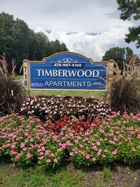 Perry apartment for rent - a sign for timbrewood subdivision with pink and white flowers
