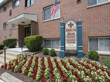 Baltimore apartment for rent - A brick building with a sign that says Arbutus Arms Apartments Leasing Center.