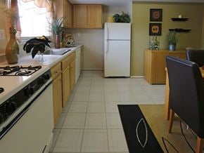 Baltimore apartment for rent - A kitchen with a white refrigerator and a black chair.