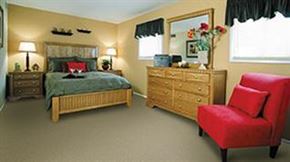 Baltimore apartment for rent - A bedroom with a bed, dresser, and chair.