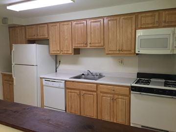 Baltimore apartment for rent - A kitchen with wooden cabinets and white appliances.