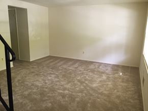 Baltimore apartment for rent - A room with a carpeted floor and a door on the left side.