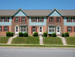 Baltimore apartment for rent - A blue and red brick house with a white door and windows.
