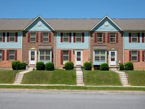 Baltimore apartment for rent - A blue and red brick house with a white door and windows.