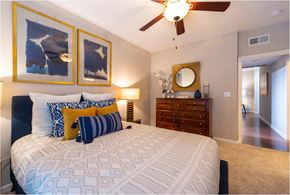 Houston apartment for rent - a bedroom with a large bed and a ceiling fan