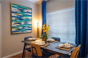 Houston apartment for rent - a dining room with a table and chairs and a painting on the wall