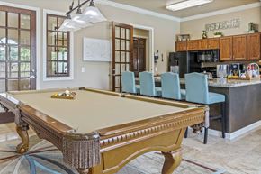 Houston townhouse for rent - A pool table is in the middle of a room with a kitchen in the background.