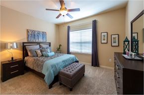 Katy apartment for rent - a bedroom with a bed and a ceiling fan