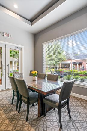 Conroe apartment for rent - A dining room with a table and chairs and an exit sign on the wall.