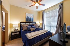 Houston apartment for rent - a bedroom with a bed and a ceiling fan