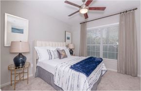 Kingwood apartment for rent - A bedroom with a bed, a ceiling fan, and a painting on the wall.