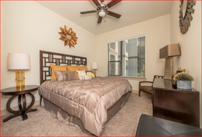 Houston apartment for rent - a bedroom with a large bed and a ceiling fan