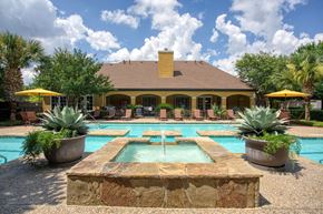 Antonio apartment for rent - a swimming pool with a fountain in front of a house