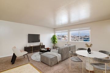 San Francisco apartment for rent - A living room with a white chair, a white table, and a grey couch.