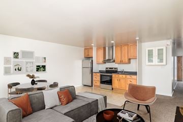 San Francisco apartment for rent - A modern living room with a grey couch and orange pillows.