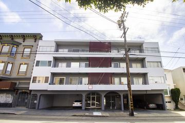 San Francisco apartment for rent - A white apartment building with a red stripe on the side.