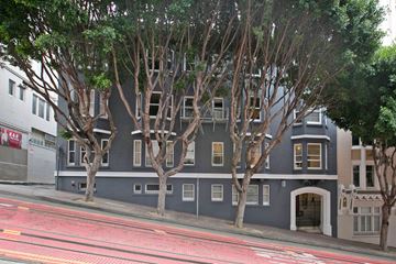 San Francisco apartment for rent - A grey building with trees in front of it.