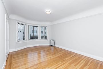 San Francisco apartment for rent - A room with wooden floors and a window with blinds.