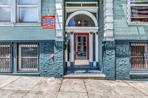 San Francisco apartment for rent - A blue building with a red door and a sign on the left.
