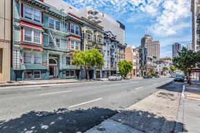 San Francisco apartment for rent - A street view of a city with buildings on the side and cars on the road.