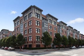 Hoboken apartment for rent - a tall brick building with cars parked in front of it